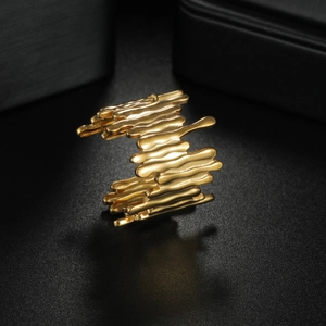 Minimalist golden titanium steel bangle with irregular lava texture and fluid design