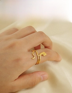Macro shot of 18K gold snake ring showing intricate scale textures on stainless steel