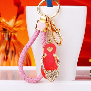 Close-up of a sparkling rhinestone heart slipper pendant with a pink braided leather strap