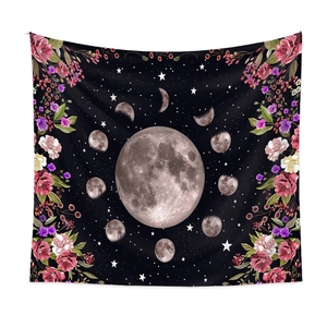 Detail of moon phase tapestry featuring floral borders and starry night sky on black fabric