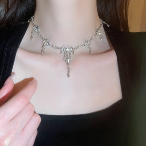 Detail of silver rhinestone oval pendant necklace with dangling charms on neck