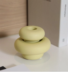 Close-up of minimalist light green ceramic candle holder with matte textured ring design