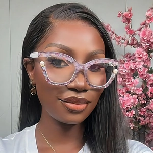 Close-up of cat-eye glasses with purple marble frames and pearl accents on the temple