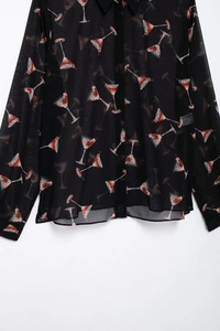 Détail d'une chemise en mousseline noire avec imprimé cocktail et col à revers boutonné