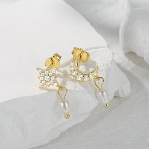 Macro shot of S925 silver star and moon earrings with pearls and zircon inlay