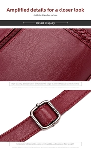 Detailed close-up of wine red litchi texture leather handbag with silver metal buckle