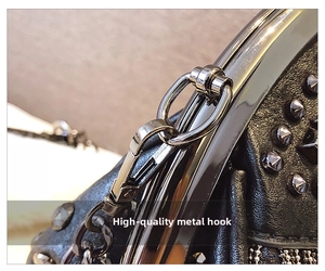 Detail of gun-black metal hook and silver rivets on textured black leather bag