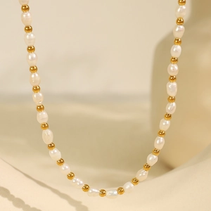 French vintage baroque freshwater pearl necklace with gold beads on beige background