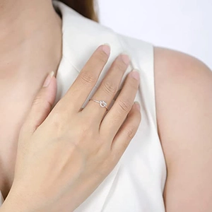 Close-up of minimalist silver heart knot ring made of titanium steel on model's finger
