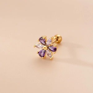 Detailed close-up of a gold flower cartilage stud with purple and clear marquise stones