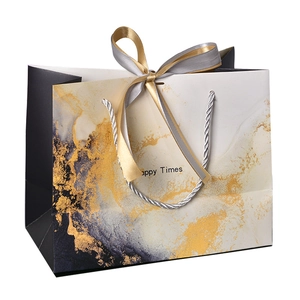 Luxury marble pattern gift bag with gold ribbons and braided handles for elegant gifting