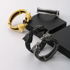 Close-up of four-color wolf head bracelets on geometric stands showing detailed metal texture