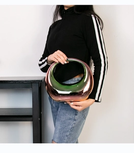 Iridescent hollow metallic handbag with colorful gradient finish held by a model