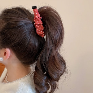 Barrette en tissu à pois ornant une queue de cheval haute sur un mannequin