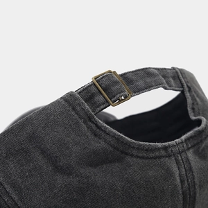 Detail of adjustable brass buckle and vintage washed cotton texture on baseball cap