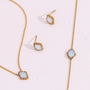 Macro detail of 18K gold-plated floral jewelry set with oval opal and zircon accents