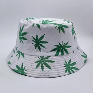 Close-up of white canvas bucket hat featuring a detailed green leaf print and fabric texture