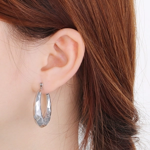 Detail showing the textured surface and C-shaped design of silver stainless steel earrings