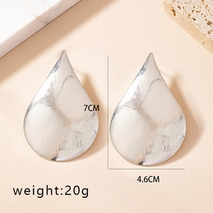 Detail shot of large silver teardrop earrings with dimensions 7CM by 4.6CM on stone