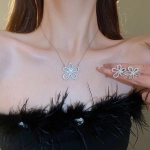 Close-up of sparkling floral pendant necklace and stud earrings set on a model