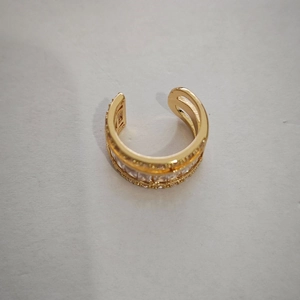 Close-up of gold ear cuff featuring multi-layer structure and clear cubic zirconia stones