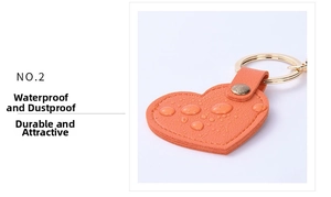 Close-up of orange heart leather keychain showing water-resistant surface and metallic ring