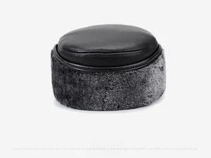 Close-up of winter flat cap showing premium black leather top and thick faux fur ear flaps