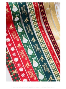 Detailed view of 5m Christmas ribbons with gold foil reindeer and Merry Christmas patterns