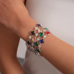 Vue détaillée de bracelets empilés avec trèfles multicolores et cristaux sertis
