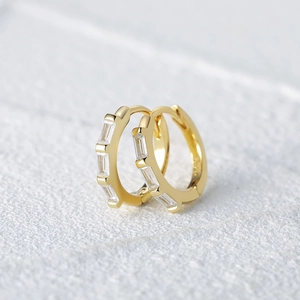 Close-up of gold s925 silver hoop earrings with rectangular baguette diamonds
