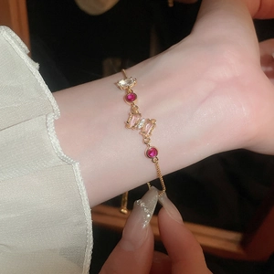 Bracelet ajustable papillon en zircon doré porté sur poignet avec dentelle élégante