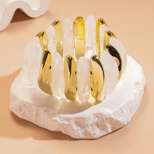 Close-up of elastic bracelet with alternating gold metal and translucent white resin beads