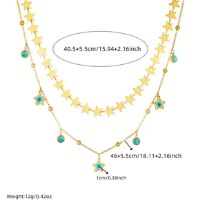 Detail of double-layer gold chain necklace with blue stone charms and star pendants