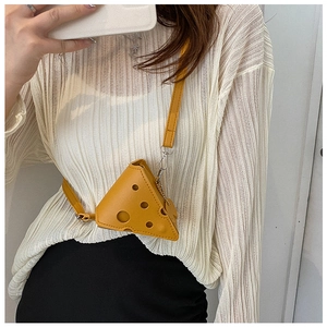 Close-up of yellow cheese-shaped mini crossbody bag worn with a casual outfit