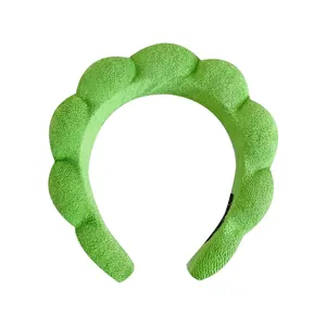 Bright green twisted sponge headband with a plush texture for face washing and styling