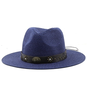Detail of dark blue straw fedora hat featuring a brown band with copper flower studs