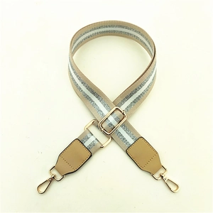 Detail of adjustable khaki wide shoulder strap with silver glitter stripe and gold hooks