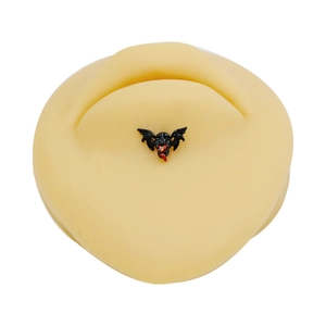 Macro shot of a gothic black bat piercing with red drip oil on a silicone skin model
