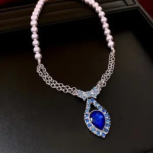 Blue teardrop crystal necklace with pearl strand and luxury bow accent for women