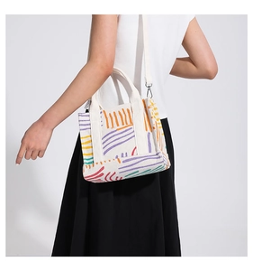 Dettaglio del motivo a righe colorate sulla borsa tote in velluto a coste beige