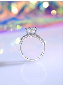 Macro side view of silver princess crown ring featuring round moissanite and double-row diamonds