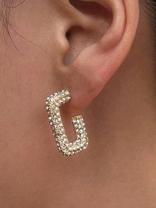 Close-up of 18K gold plated U-shaped earrings with full pave set crystals on female ear