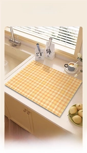 Detailed scene of large orange checkered absorbent mat on kitchen countertop