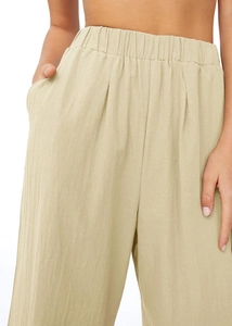 Gros plan du pantalon en lin kaki clair montrant la taille élastique et la texture du tissu