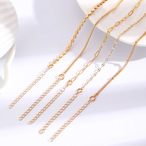 Detailansicht von fünf verschiedenen goldfarbenen Metallarmbändern auf weißem Tablett