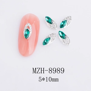 Dettaglio di ciondoli per unghie marquise smeraldo 5x10mm con strass su unghia rosa
