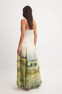Detail of the back view of a white floral maxi dress with green scenic oil painting print