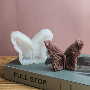 Gedetailleerd zicht op 3D-vlinder siliconen mal en afgewerkt getextureerd waskaars