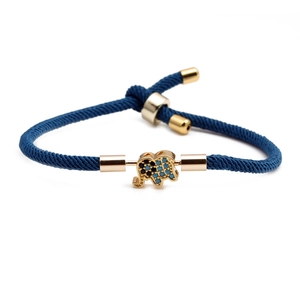 Adjustable blue braided rope bracelet featuring a gold-plated pavé crystal elephant charm