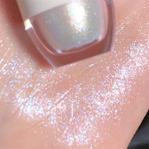 Macro di ombretto liquido glitterato applicato sulla pelle per un effetto ultra luminoso